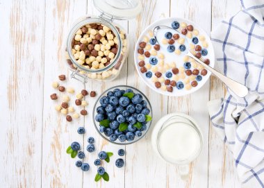 İki aromalı mısır topları ve beyaz ahşap bir masada yaban mersinli sağlıklı bir kahvaltı..