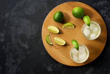 Siyah bir masada limon ve tuzla süslenmiş klasik margarita kokteyli..