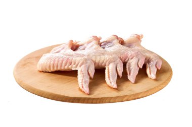 Beyaz arka planda izole edilmiş kesme tahtasındaki taze çiğ tavuk kanatları..