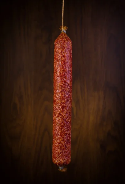 Golden salami sausages on a wooden background — Stock Photo, Image