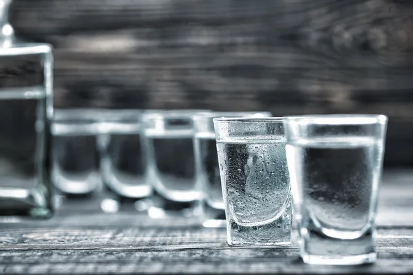 Selectiv gafas de foco de vodka en la mesa de madera — Foto de Stock