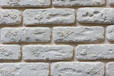 Beyaz dekoratif desenli, istiflenmiş taş, doğal taş kaplama. tuğla arka plan. Kapat. Arkaplan.