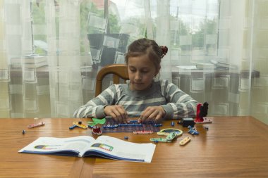 Pozitif kadın oyuncaklarla oynuyor. İnşaatçıdan yapıyor. Eğlence konsepti. Eğitim, çocuklar, teknoloji, bilim ve fütüristik kavram. E-öğrenme. ses tonlu.