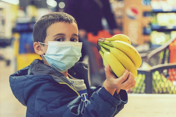 Cerrahi Maske Takan Bir Çocuk Coronavirus Salgınında Marketten Meyve Alıyor — Stok fotoğraf