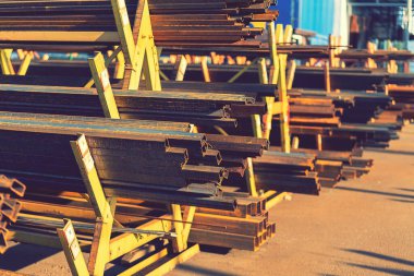 Rafta çelik borular ve metal kirişler var. Metal borular, profiller, çubuklar, köşeler, raylar, metal ürünlerin seçimi. Metal atölyesi. ses tonlu.