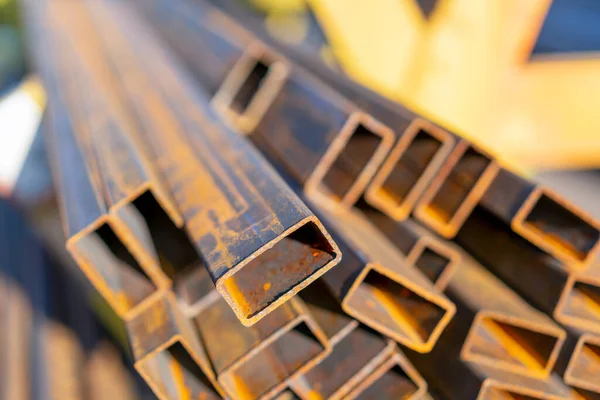 stack of steel pipe and metal beams on rack. metal pipes, profiles, rods, corners, rails, a choice of metal products. Metal shop. toned.