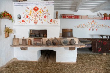 Etnik havlular, bir sürü kuru çiçek ve beyaz duvarlarda tarihi simgeler. Pencerenin yanındaki ahşap banklar. Ukrayna 'daki ulusal kırsal yaşam müzesinin eski iç odaları..