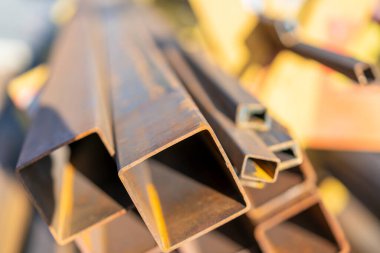 Rafta çelik borular ve metal kirişler var. Metal borular, profiller, çubuklar, köşeler, raylar, metal ürünlerin seçimi. Metal dükkanı..