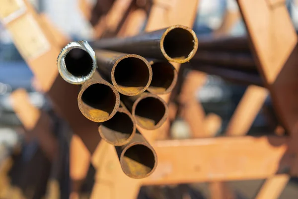 stack of steel pipe and metal beams on rack. metal pipes, profiles, rods, corners, rails, a choice of metal products. Metal shop.