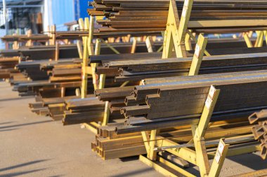 Rafta çelik borular ve metal kirişler var. Metal borular, profiller, çubuklar, köşeler, raylar, metal ürünlerin seçimi. Metal atölyesi. ses tonlu