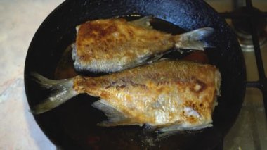 Mutfak ortamında soba çubuğu olmayan bir tavada pişirilmiş balık fotoğrafçılığı. Tavada kızartılmış tatlı su balığı.