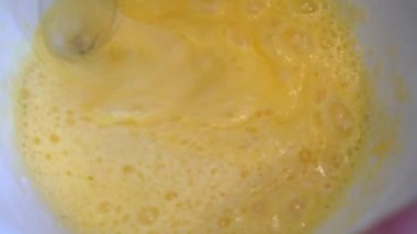 Ahşap masada çırpılmış yumurta. Manzaralı. Kahvaltıyı yumurtadan hazırla. Ev yapımı hamur için el çırpma malzemesi pişirir. Yumurta çırpıyorum. Çikolatalı Kek Yapıyorum. Seri