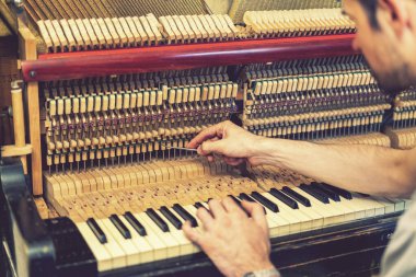 Piyano akort işlemi. Büyük piyanoda çalışan el ve akort aletlerinin yakın çekimi. Akort sırasında Upright Piano 'nun detaylı görüntüsü. ses tonlu.