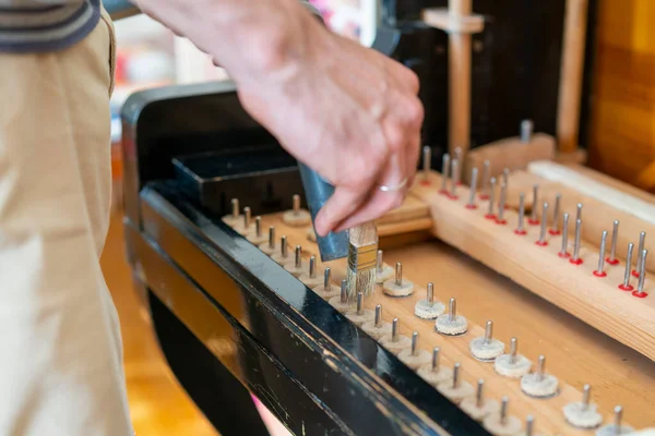 Setting up an old piano. The master repairs an old piano. Deep cleaning the piano. Hands of professional worker repairing and tuning an old piano. toned.