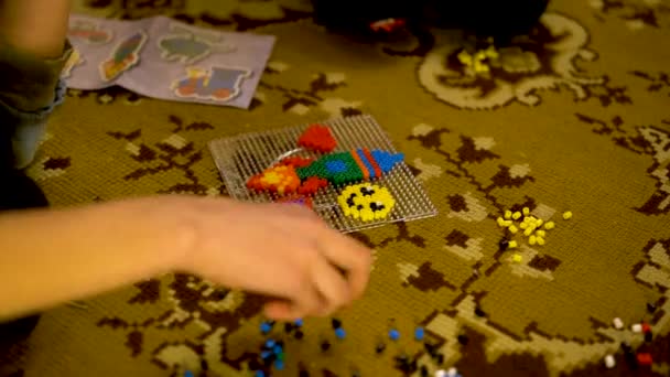 Dziecko gra w intelektualną grę edukacyjną. Dziecko układa puzzle. Gry logiczne dla dzieci na ruchliwość ręki. Kolorowe kulki konstruktor dla dzieci — Wideo stockowe