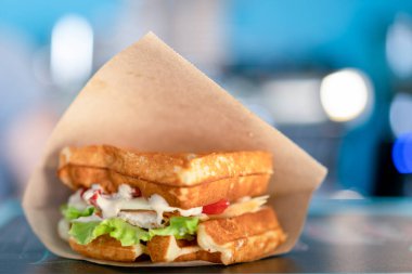 Kese kağıdında sandviç, yakın plan. Sandviç fileto americain, hamburgerin kapağı. Hızlı ama sağlıksız yiyecekler.