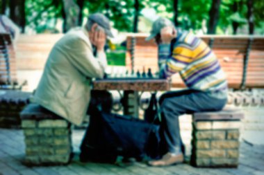 Satranç oynayan iki yaşlı adam. Aktif emekliler, eski dostlar ve boş zaman. Aktif emekliler, eski dostlar ve boş zaman. İki son sınıf öğrencisi parkta satranç oynuyor. Bulanık. ses tonlu