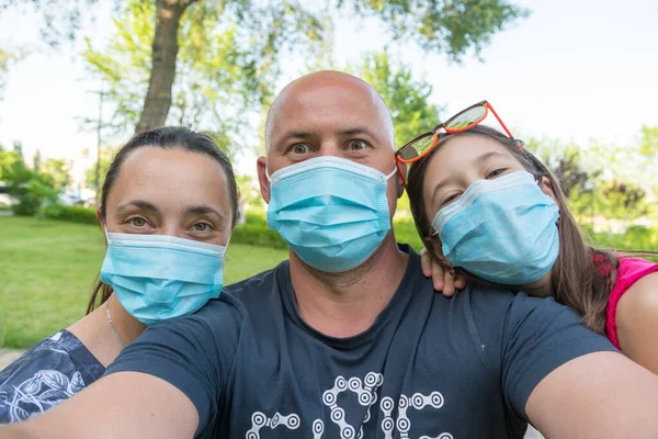 Family in protective medical masks. Mother, father, daughter protect themselves from the virus Coronavirus. Family in medical masks outdoors. close up