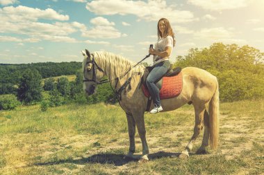 Beyaz atın binicisi. Beyaz ata binen genç bir at, açık hava manzaralı. Beyaz atlı kız özgürce koşuyor. ses tonlu