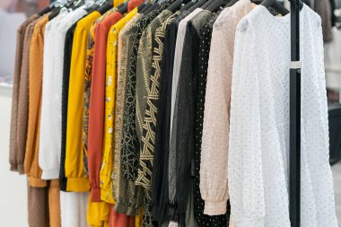 Mağazada bahar ve yaz kadın kıyafetleri var. Parlak, modern kıyafetler bir butikte. Kadınların kalça giyim mağazası iç konsepti. Kıyafet seçimi konsepti. ses tonlu