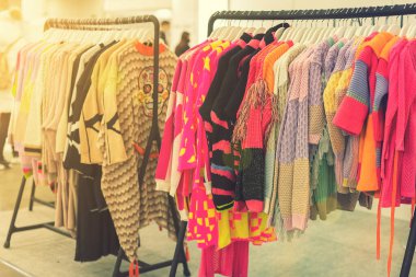 Mağazada bahar ve yaz kadın kıyafetleri var. Parlak, modern kıyafetler bir butikte. Kadınların kalça giyim mağazası iç konsepti. Kıyafet seçimi konsepti. ses tonlu