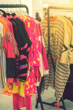 Mağazada bahar ve yaz kadın kıyafetleri var. Parlak, modern kıyafetler bir butikte. Kadınların kalça giyim mağazası iç konsepti. Kıyafet seçimi konsepti. ses tonlu