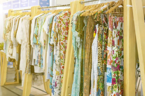 Ropa de las mujeres de primavera y verano en la tienda. ropa brillante y moderna en una boutique. Mujer ropa de la cadera tienda concepto interior. concepto de elección de la ropa. tonificado Fotos De Stock Sin Royalties Gratis