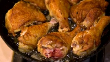 Tavuk bacağı sebze yağında büyük bir tavada kızartılır. Kızartma tavasında ızgara kümes hayvanlarının üst görüntüsü. Taze tavuk eti. Fırında tavada kızartılmış.