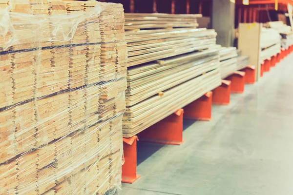 Viele Holzbohlen im Baumarkt. Holzplanken stapeln sich im Baustofflager. Platten in einem Baumarkt. Reparatur- und Baukonzept — Stockfoto