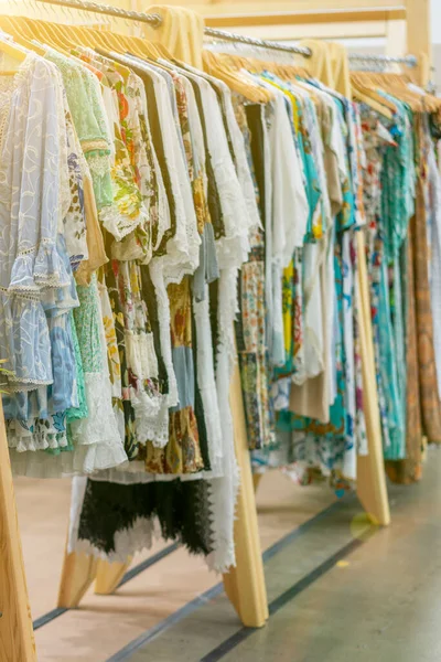 Ropa de las mujeres de primavera y verano en la tienda. ropa brillante y moderna en una boutique. Mujer ropa de la cadera tienda concepto interior. concepto de elección de la ropa. tonificado — Foto de Stock