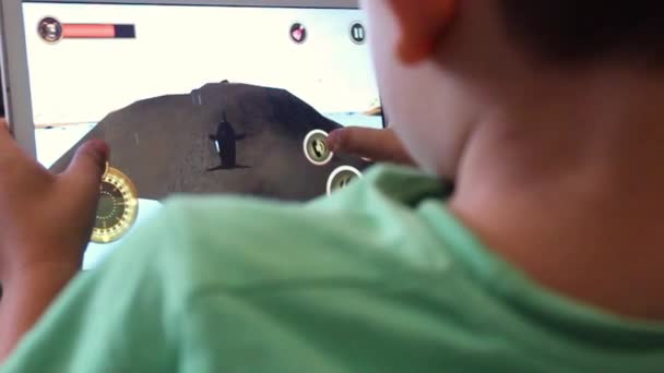 Мальчик играет в игру на планшете — стоковое видео
