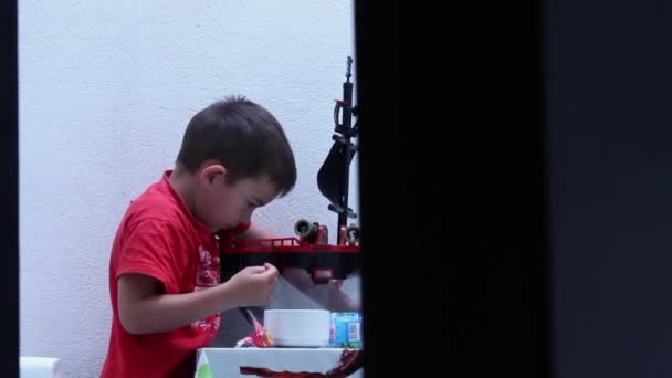 Kisfiú játszik a tornácon — Stock videók
