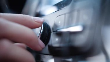 Şoför arabadaki radyoyu akort eder.