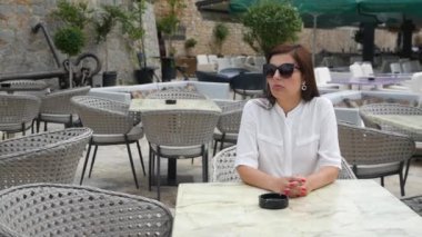Kız bir restoranda bir masada oturuyor.