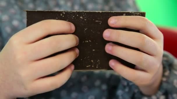 Man breekt de reep van donkere chocolade — Stockvideo