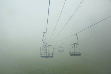 Yaz sisli sabahı, sessizlik ve Baykal Gölü kıyısındaki Listvyanka 'da bir teleferik.