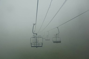 Yaz sisli sabahı, sessizlik ve Baykal Gölü kıyısındaki Listvyanka 'da bir teleferik.