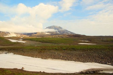 Mavi gökyüzünün arkaplanındaki dağ manzarası ve Kamçatka 'da yaz güneşli günü