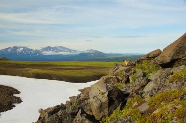 Mavi gökyüzüne karşı bir taş sincabı ve Kamçatka 'da güneşli yaz sabahı, dağ manzarası