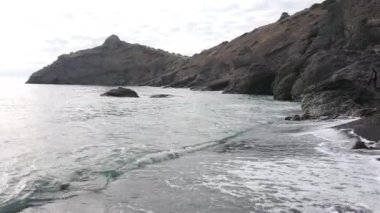 Sıcak denizin kıyısında sakin bir sonbahar sabahı, sakin bir körfezde kumsal.