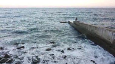 Sıcak denizin kıyısında sakin güneşli bir akşam, balıkçılar balık yakalar.