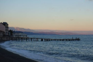 Sıcak bir sonbahar akşamı ve şehir plajı boyunca sakin bir yürüyüş.
