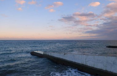 Sıcak bir sonbahar akşamı ve şehir plajı boyunca sakin bir yürüyüş.