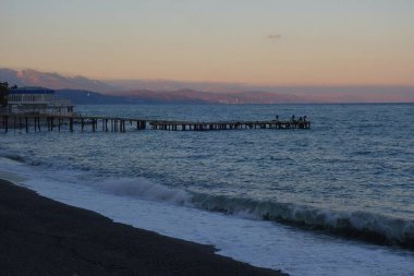 Sıcak bir sonbahar akşamı ve şehir plajı boyunca sakin bir yürüyüş.