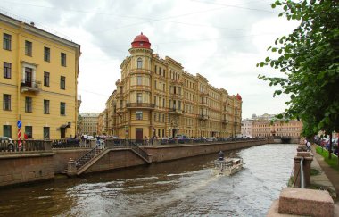 Sıcak bir yaz akşamı ve tarihi bir binanın ön cephesinin bir parçası olan Griboyedov Kanalı 'nın setinde bir yürüyüş.