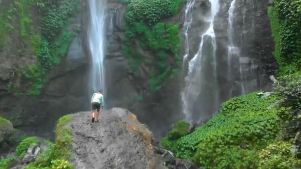 Dron Wielki wodospad na Bali i mężczyzna patrzący w górę — Wideo stockowe