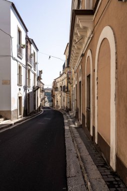 Geleneksel cepheleri, balkonları ve güneş ışığıyla tarihi bir kasabada sessiz dar bir cadde..