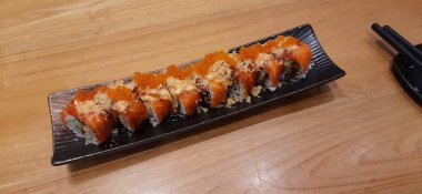 Salmon Crispy Sushi Roll with Orange Tobiko Served on a Plate. Presentation Japanese Food Photography