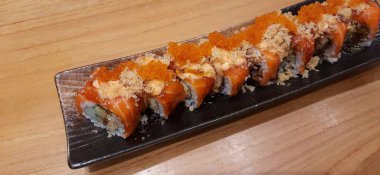 Salmon Crispy Sushi Roll with Orange Tobiko Served on a Plate. Presentation Japanese Food Photography