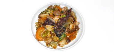 Capcay Goreng, kızarmış sebzeleri karides, köfte, tavuk ve mantarla karıştır. Beyaz arkaplanda izole edilmiş beyaz plaka ile servis edilir